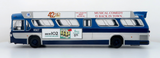 A scale model of a vintage blue and white bus, featuring printed advertisements on its side, photographed against a clean white background.